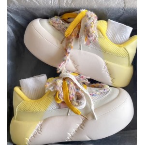 Масивні жіночі кросівки на високій підошві з жовтим задником та рваними шнурками